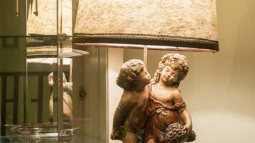 A table lamp with a textured shade and a base featuring a sculpture of two figures.