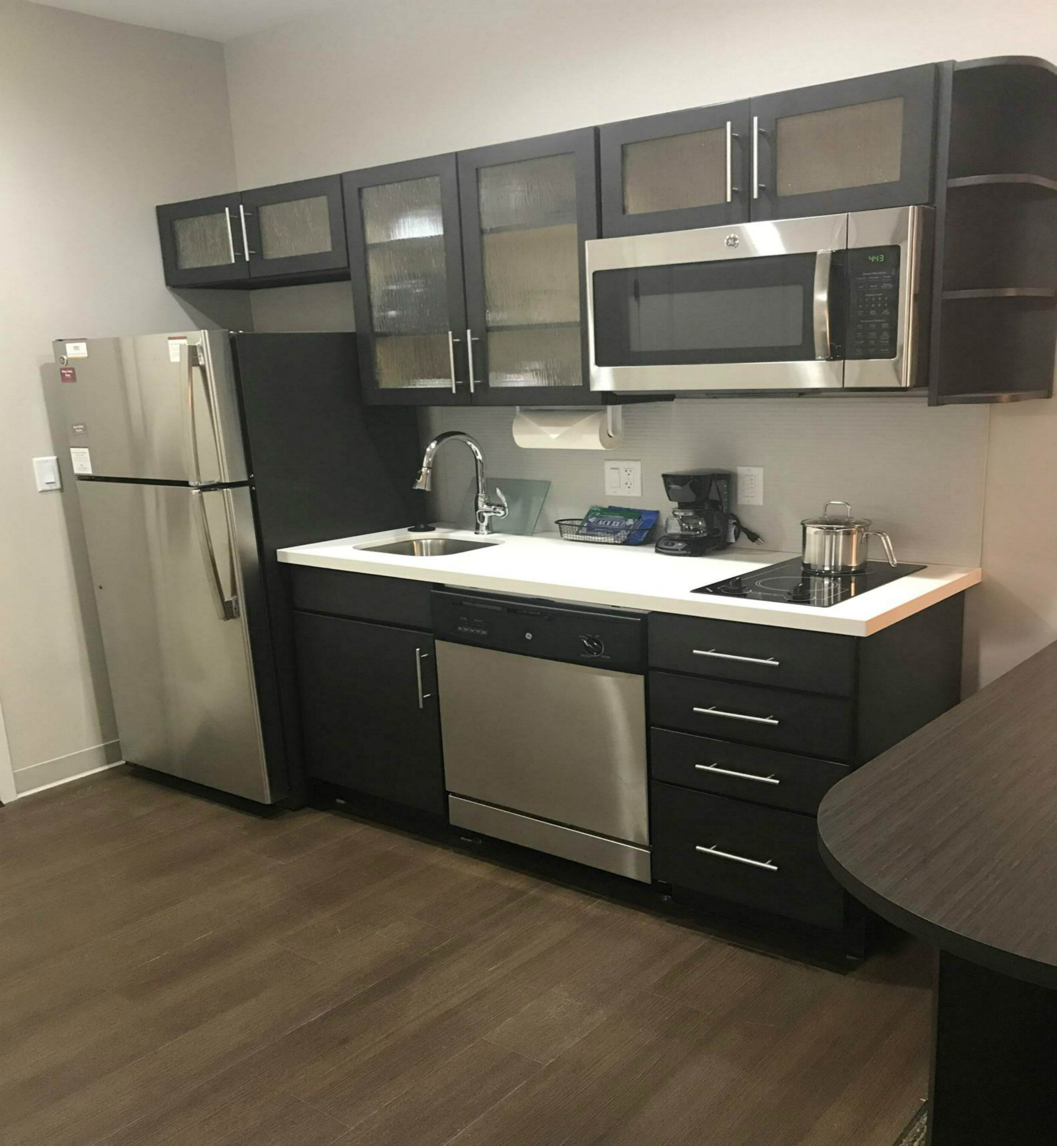 A modern kitchen with stainless steel appliances, a dishwasher, and a microwave.