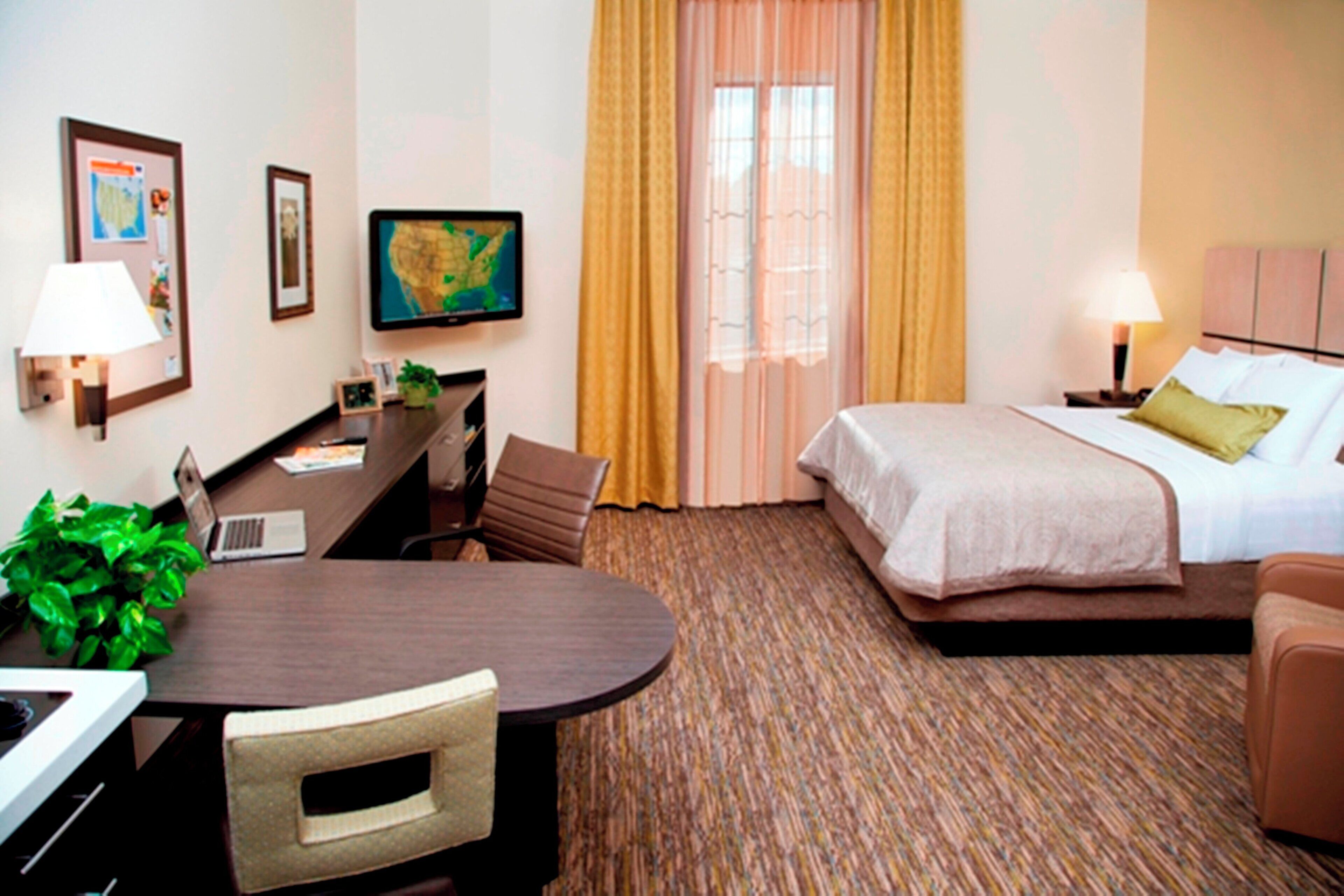 Une chambre d’hôtel équipée d’un lit, d’un bureau, d’une chaise et d’un téléviseur.