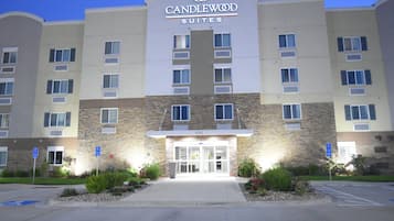 A hotel with a stone facade, multiple windows, and a sign indicating it is Candlewood Suites.