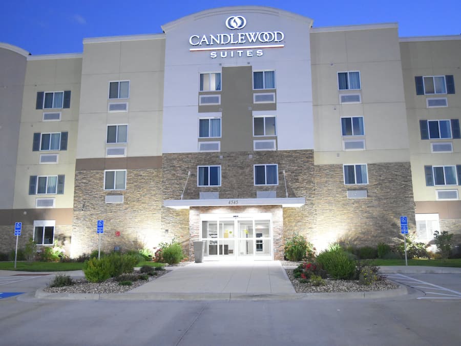 Un hôtel à la façade en pierre, doté de nombreuses fenêtres et d’une enseigne indiquant qu’il s’agit d’un établissement Candlewood Suites.
