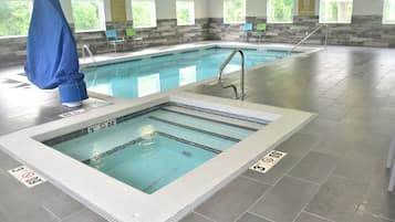 Una piscina techada, sillones reclinables de piscina