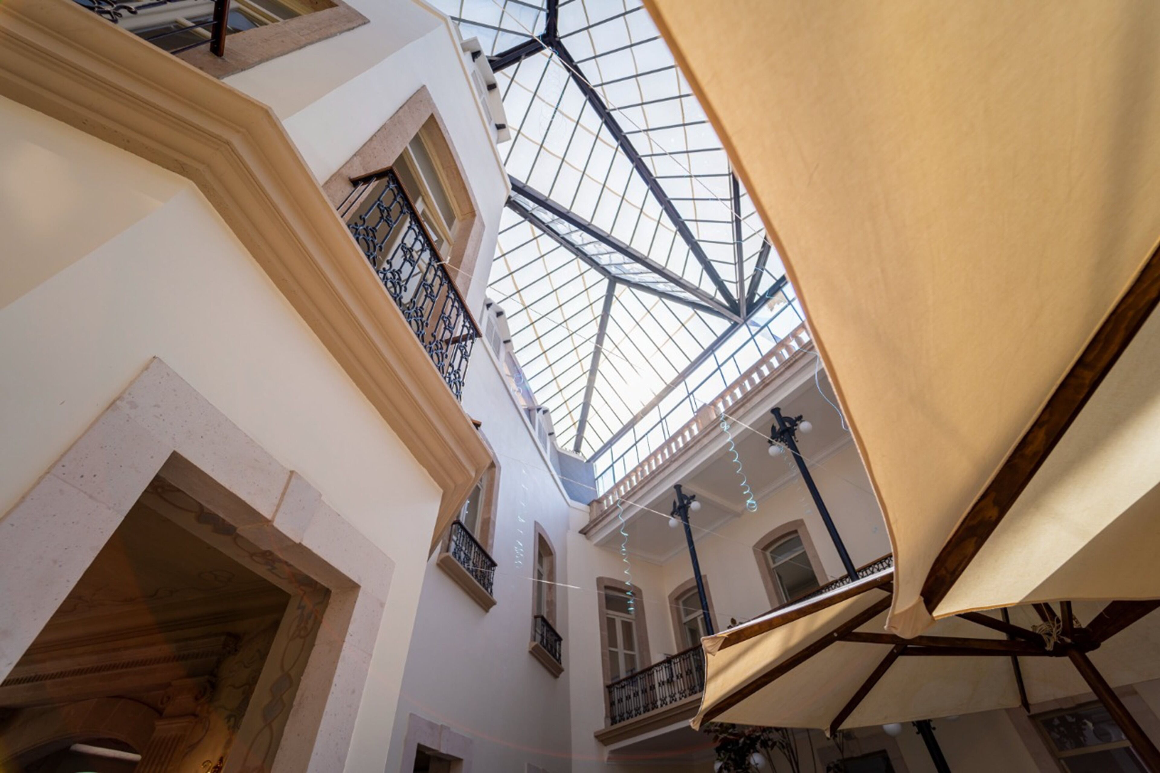 A multi-level interior with a glass ceiling, balconies, and a central open space.