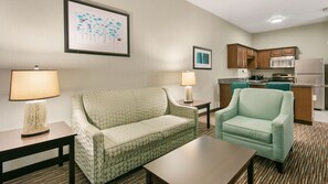 Relax in comfort with a sofa, armchair, and compact kitchenette.