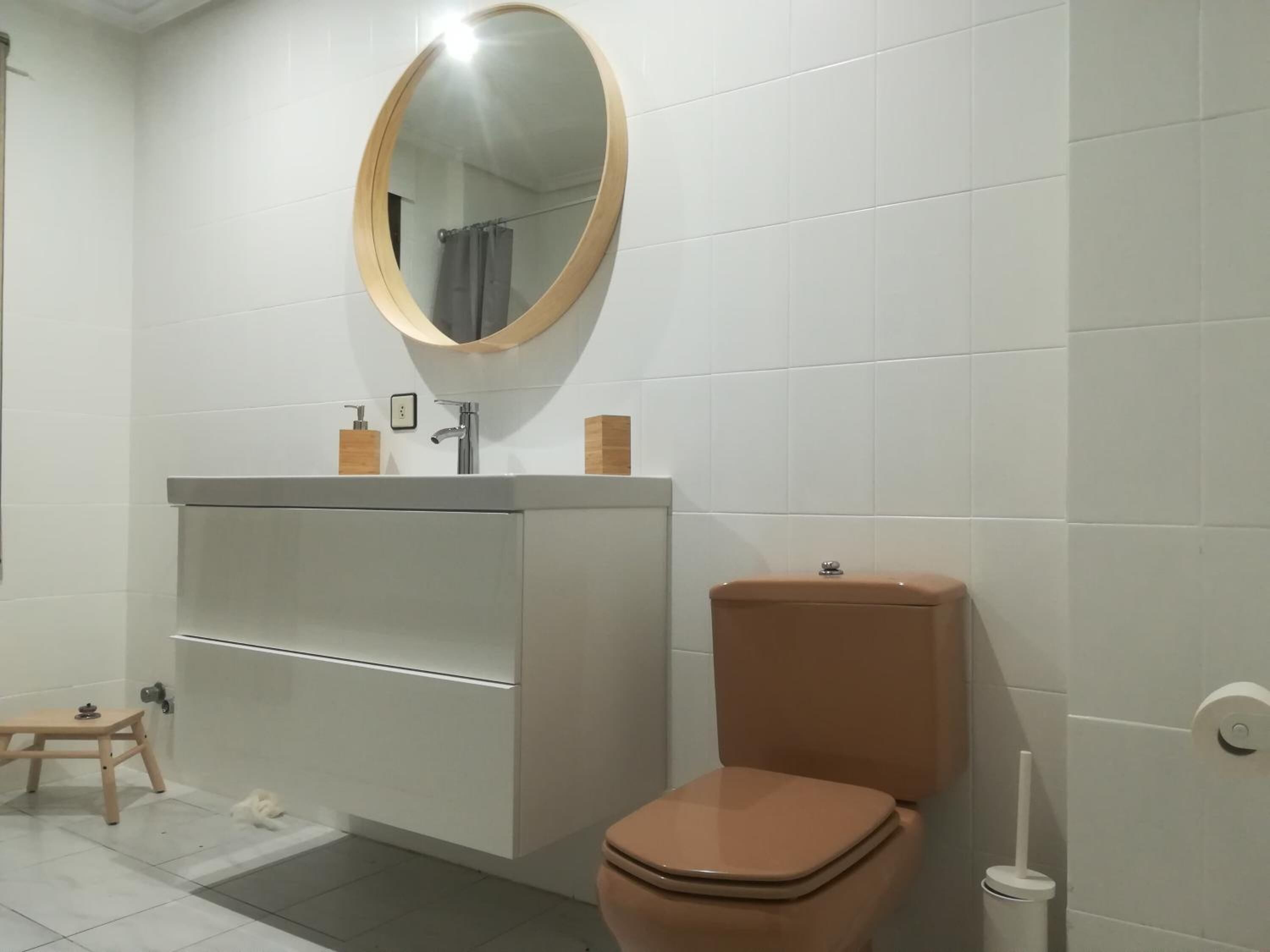 Un baño con inodoro, lavamanos y espejo.