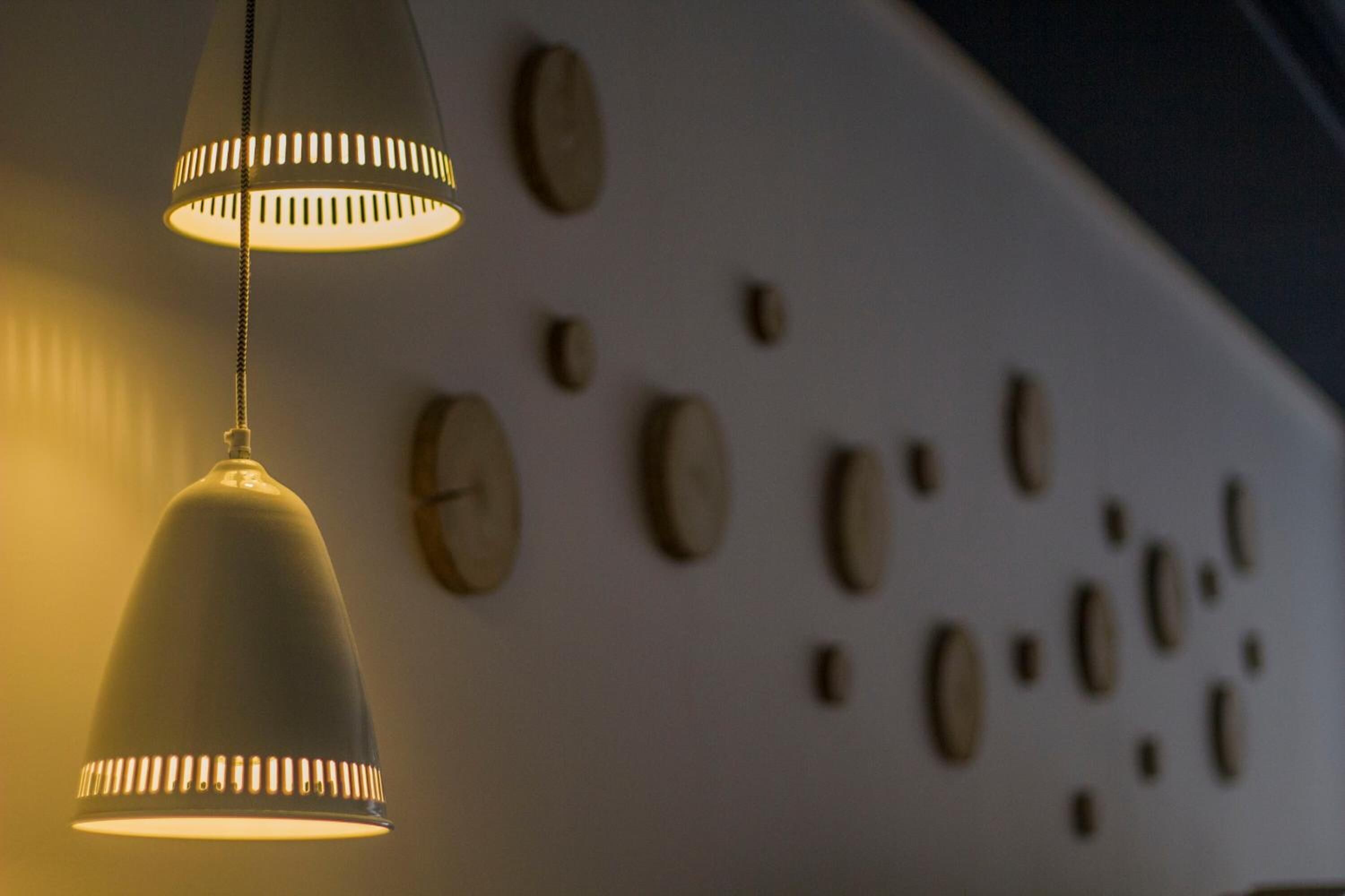 Una lampada a sospensione con paralume conico e catena, appesa al soffitto.