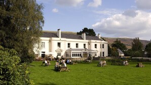 A large white building with a garden patio area. - Premier Inn Merthyr Tydfil (Merthyr Tydfil)