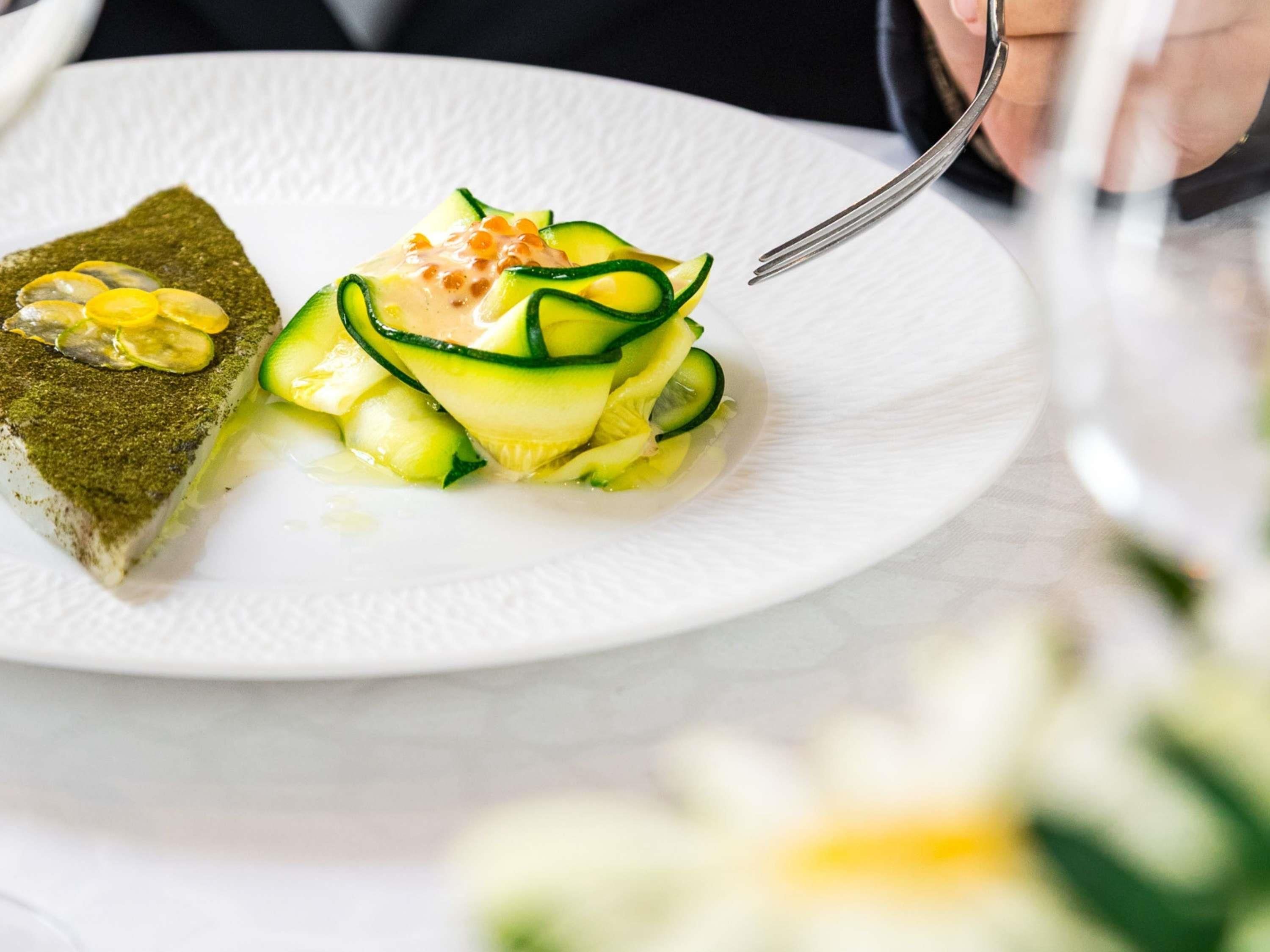 Un plato de postre con una rebanada de pastel y una ensalada de pepino.