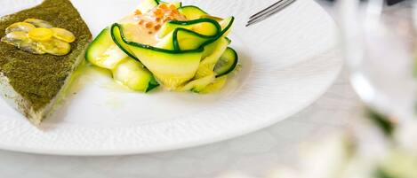 Un plato de postre con una rebanada de pastel y una ensalada de pepino.