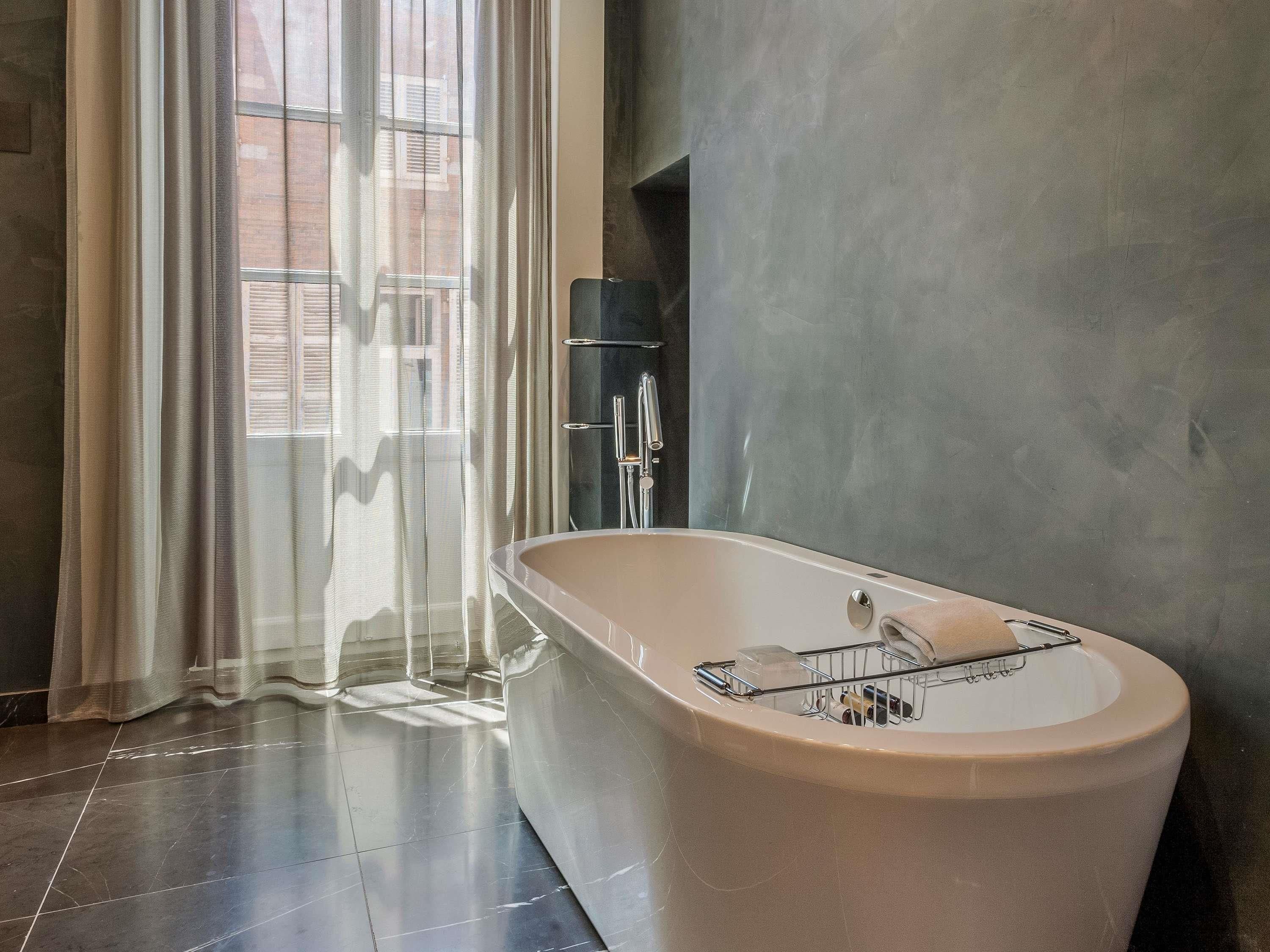 Ein modernes Badezimmer mit einer freistehenden Badewanne, einem Handtuchhalter und einer Duschkabine.