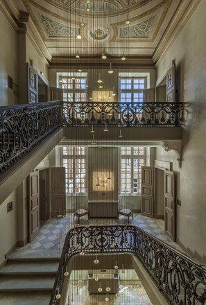 A grand interior with a double staircase, ornate railings, and a high ceiling with decorative moldings. - La Cour des Consuls Hotel & Spa Toulouse - MGallery Collection (Toulouse)