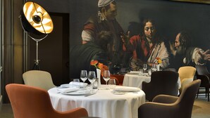 A dining area with round tables, chairs, and a large painting on the wall. - La Cour des Consuls Hotel & Spa Toulouse - MGallery Collection (Toulouse)