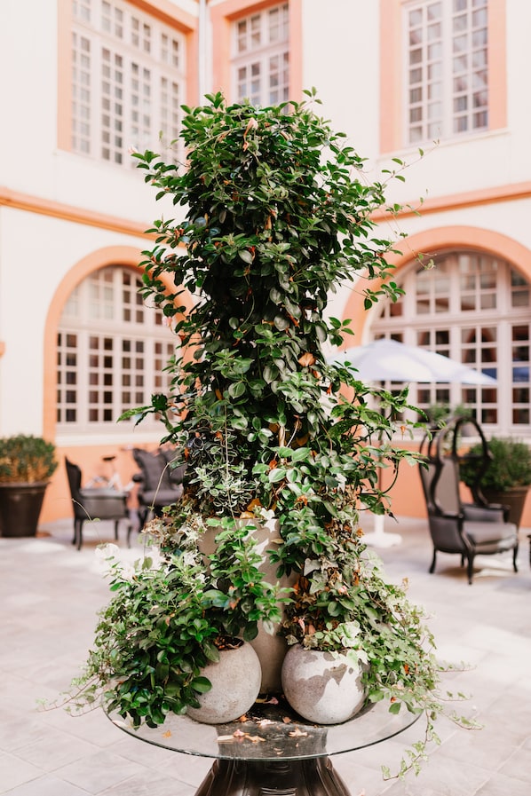 A tiered planter with various plants in an outdoor setting with a building in the background. - La Cour des Consuls Hotel & Spa Toulouse - MGallery Collection (Toulouse)