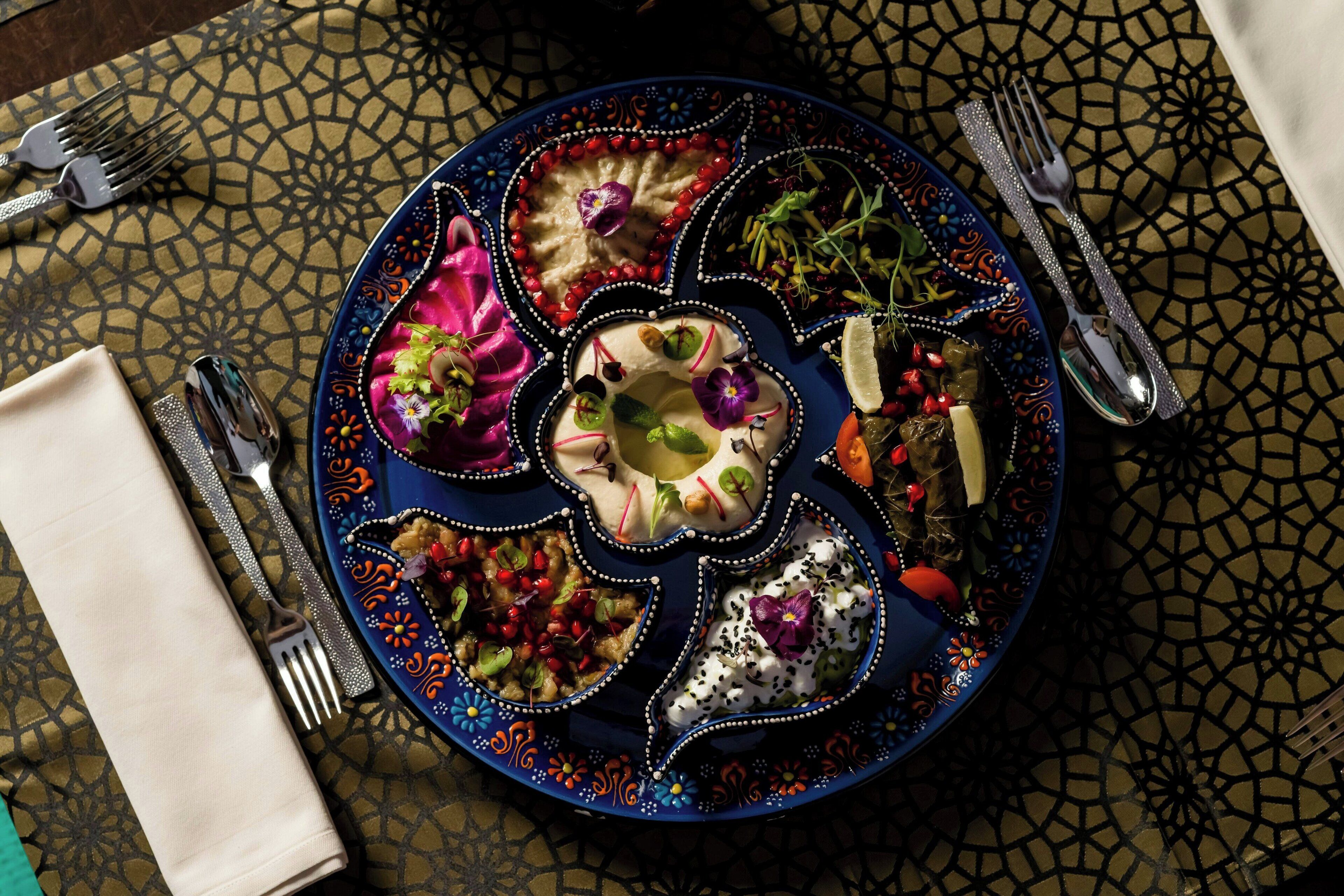 A table with a decorative plate of food, a napkin, and cutlery.