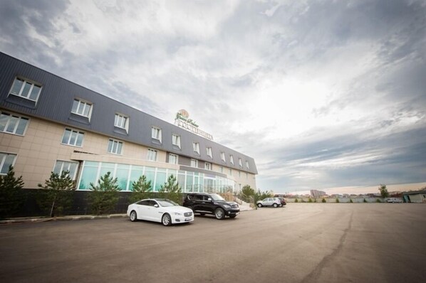 A modern building with a parking lot and several cars.