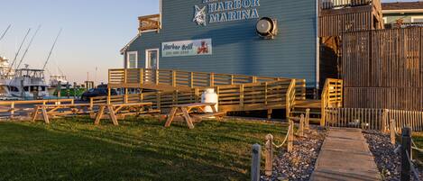 Ein Gebäude am Wasser, das 'Hatteras Harbor Marina' genannt wird, mit einem Schild für das 'Harbor Grill'.