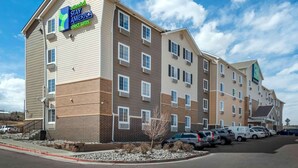 Un hotel a più piani con insegna Extended Stay America, caratterizzato da pareti esterne in tonalità beige e marrone, numerose finestre e un parcheggio con diverse auto.