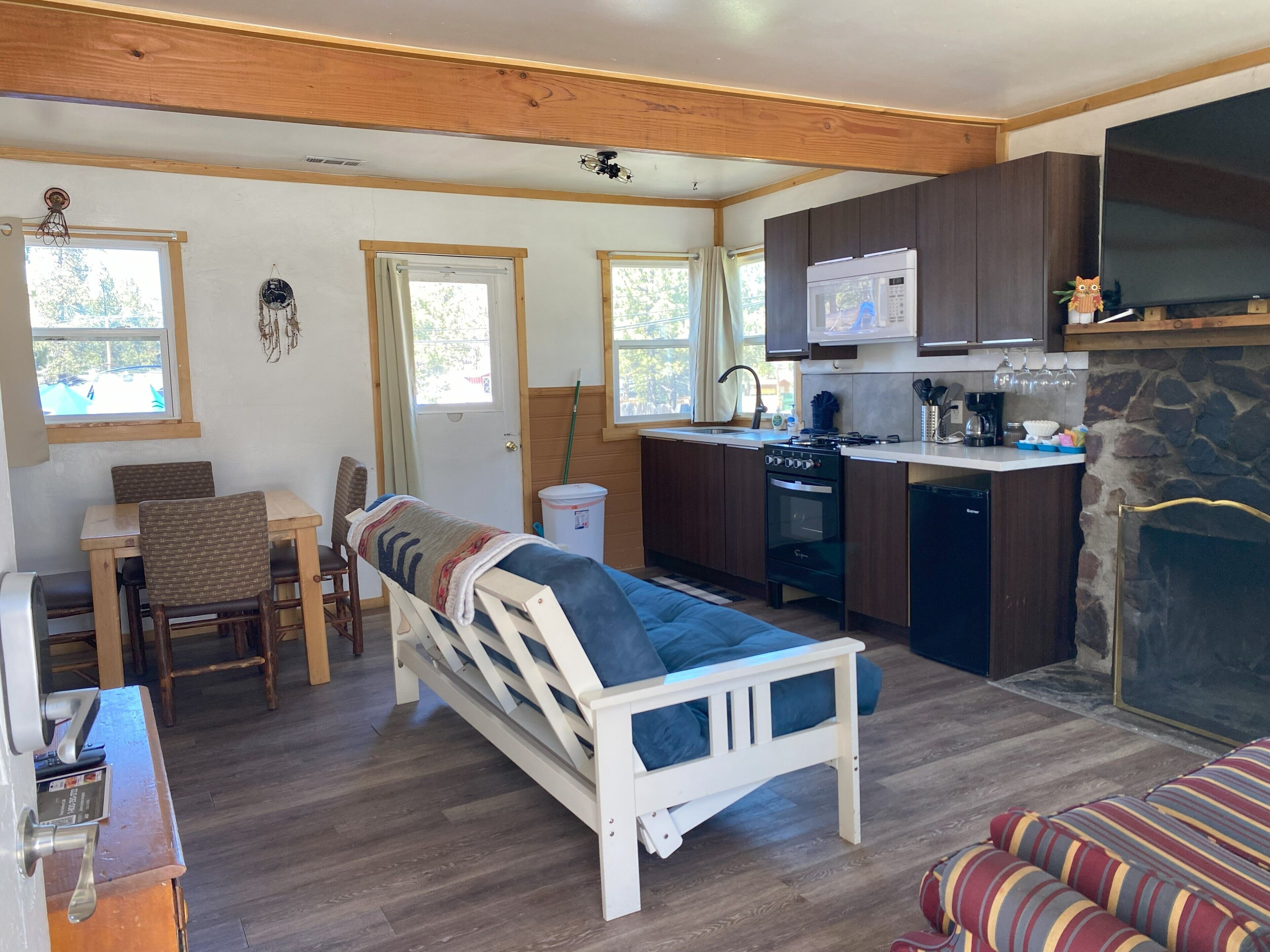 A compact living space with a kitchenette, a bed, a dining area, and a fireplace.