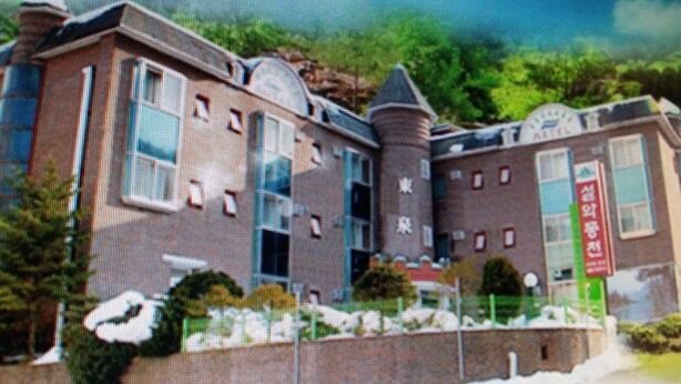 Um edifício com vários andares, com espaços residenciais e comerciais, incluindo uma loja com sinalização.