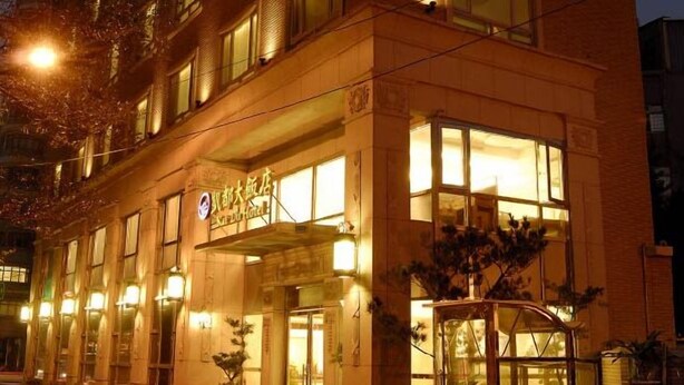 A multi-story hotel with illuminated signage and windows. - Kai Du Hotel (Taoyuan City)