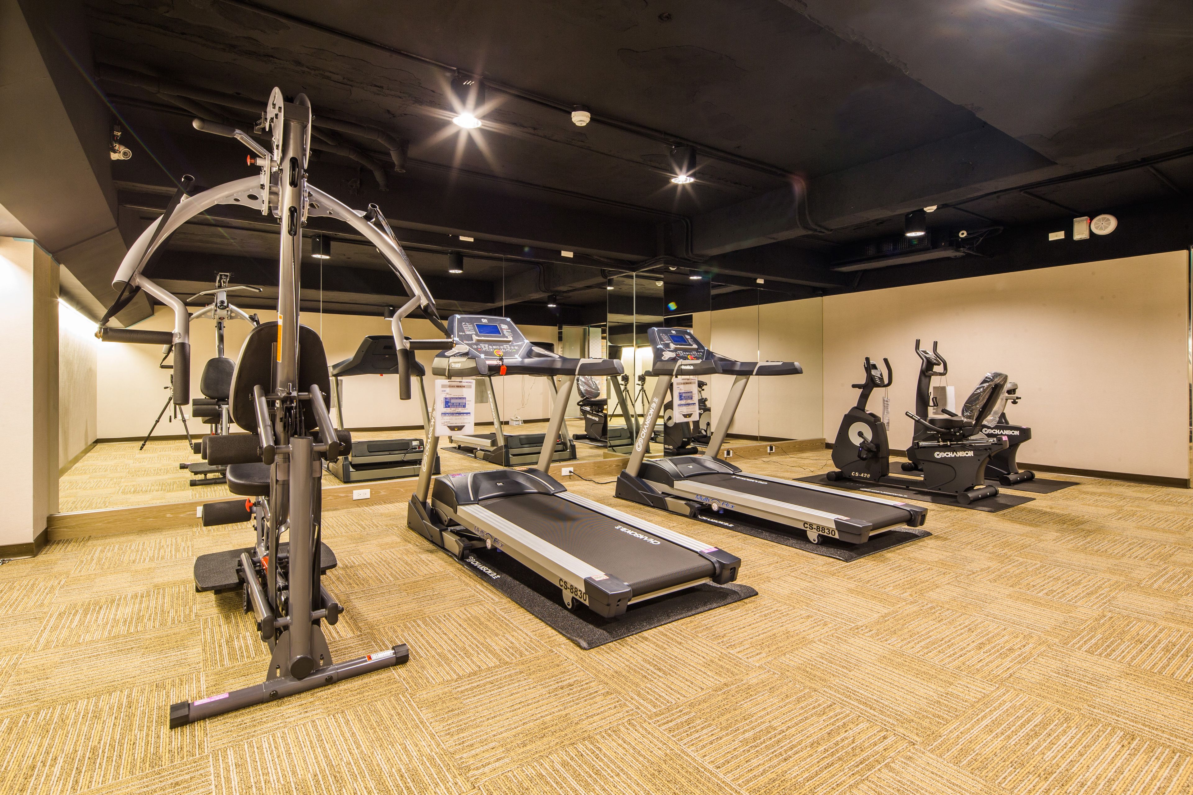 A gym with treadmills, a weight machine, and a stationary bike.
