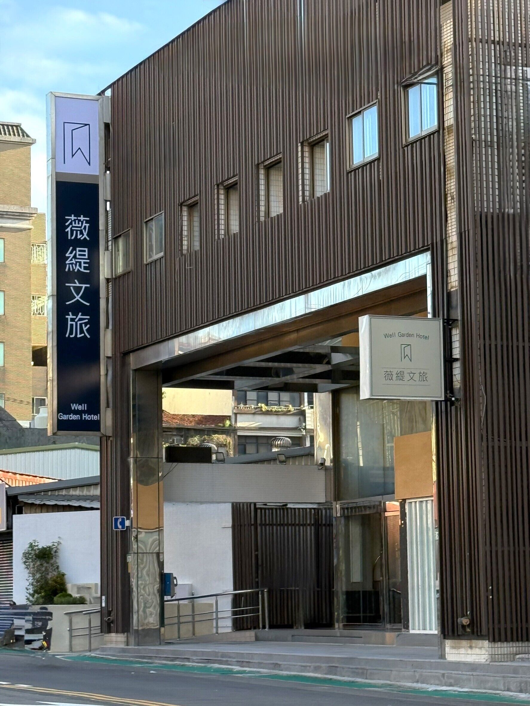 Un edificio moderno con un letrero del Hotel Well Garden.