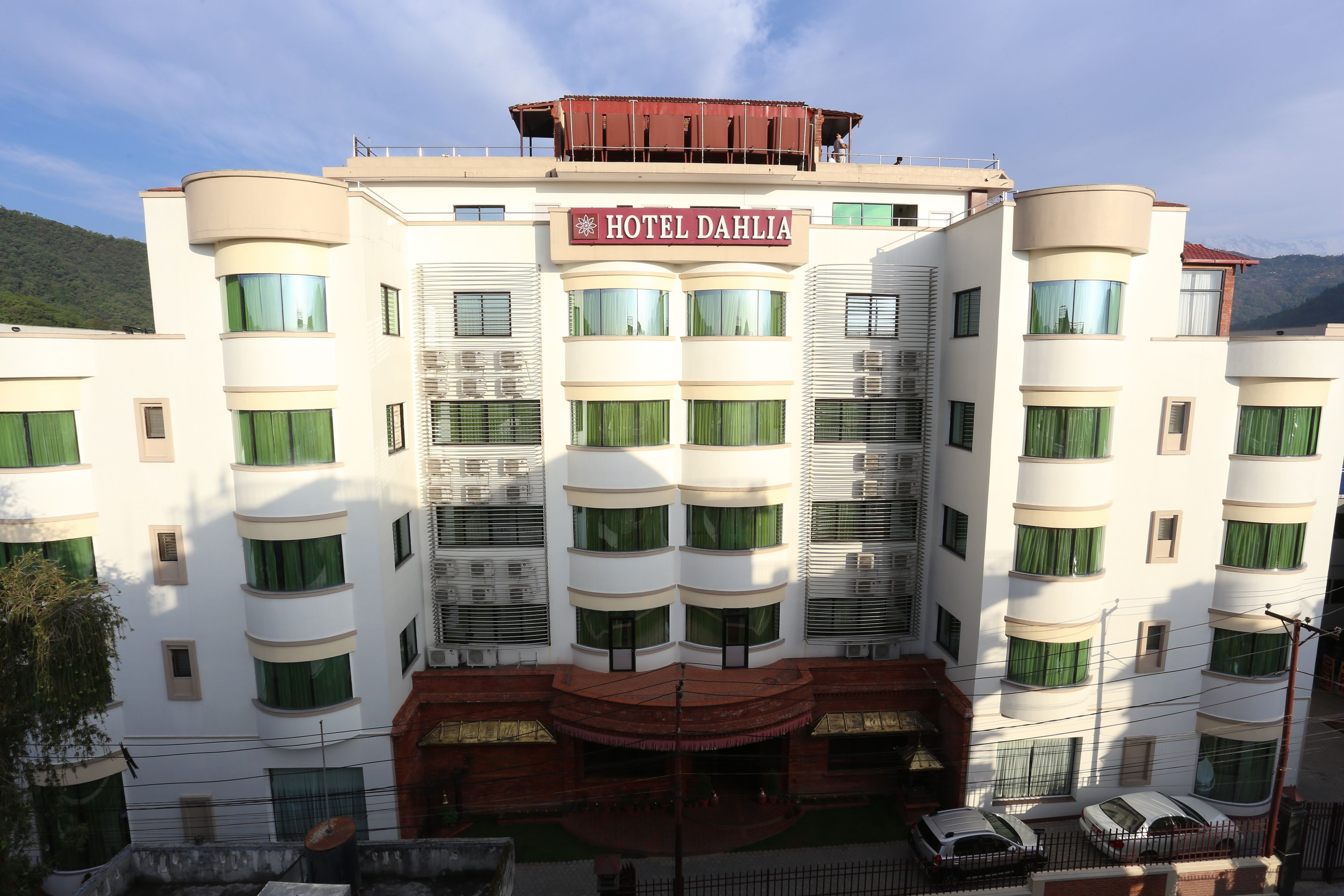 A multi-story hotel with a prominent sign reading "HOTEL DAHLIA".