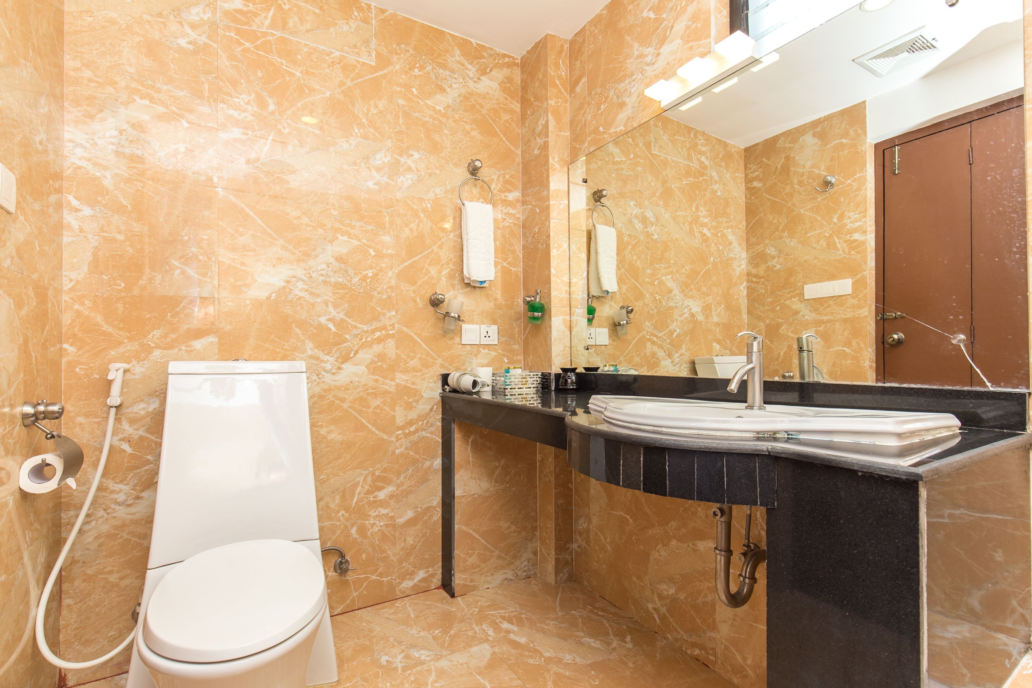 Un baño con inodoro, lavamanos y espejo.