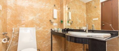 Un baño con inodoro, lavamanos y espejo.