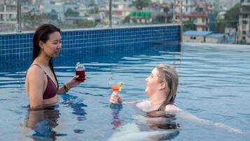 Relax by the serene pool, surrounded by a tranquil urban view.