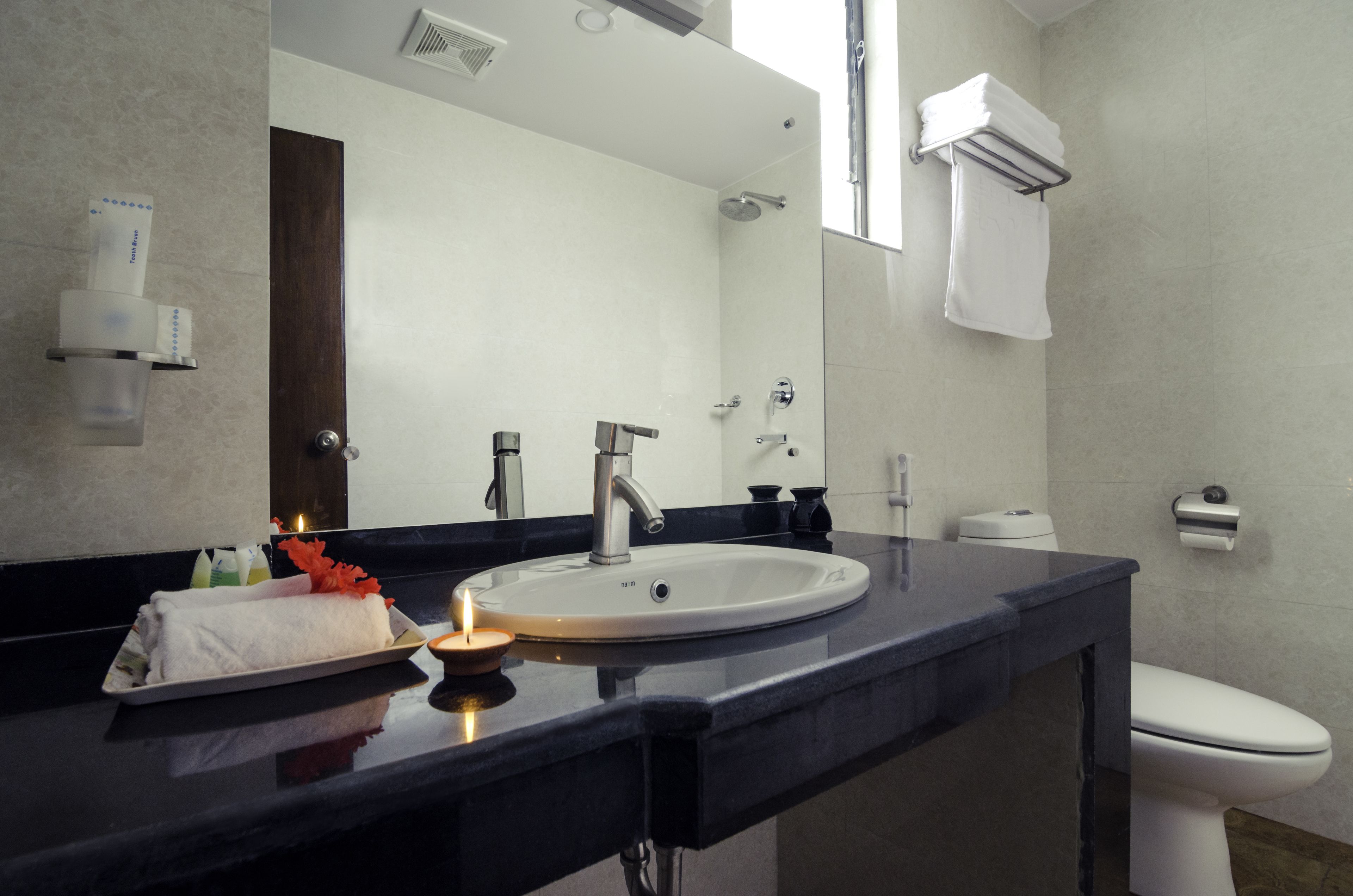Ein modernes Badezimmer mit einem großen Waschbecken, einem Spiegel und einer Toilette.