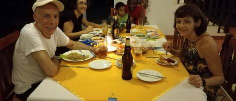 Una mesa de comedor con platos de comida, botellas y vasos.