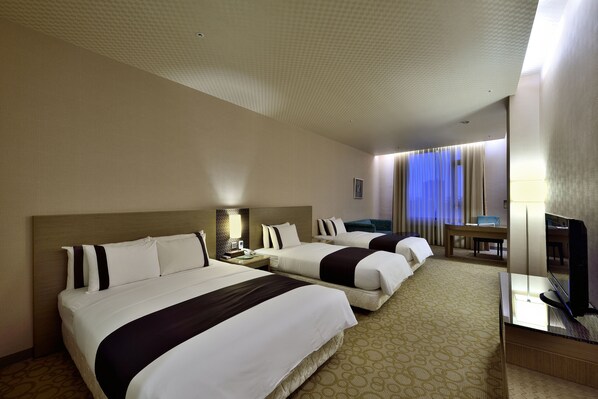 A hotel room with two beds, a desk, a TV, and a bathroom. - Shinkansen Grand Hotel (Taichung)