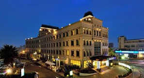 A multi-story hotel with a classic architectural style, featuring a central courtyard with outdoor seating and a well-lit entrance. - Shinkansen Grand Hotel (Taichung)