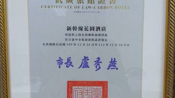 A framed certificate of law-carbon hotel from Taichung City Government.