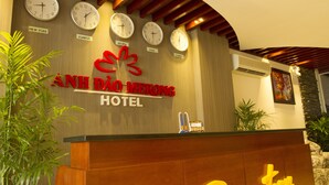 Een hotel receptiebalie met klokken die de tijd weergeven voor New York, Londen, Hong Kong, Parijs en Sydney.