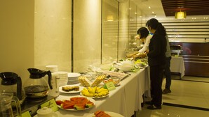 Een buffetopstelling met diverse gerechten en een koffiehoek.