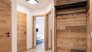 A hallway with wooden doors and a bench. - AvenidA Style Appartments by Alpin Rentals -incl Summercard (Kaprun)