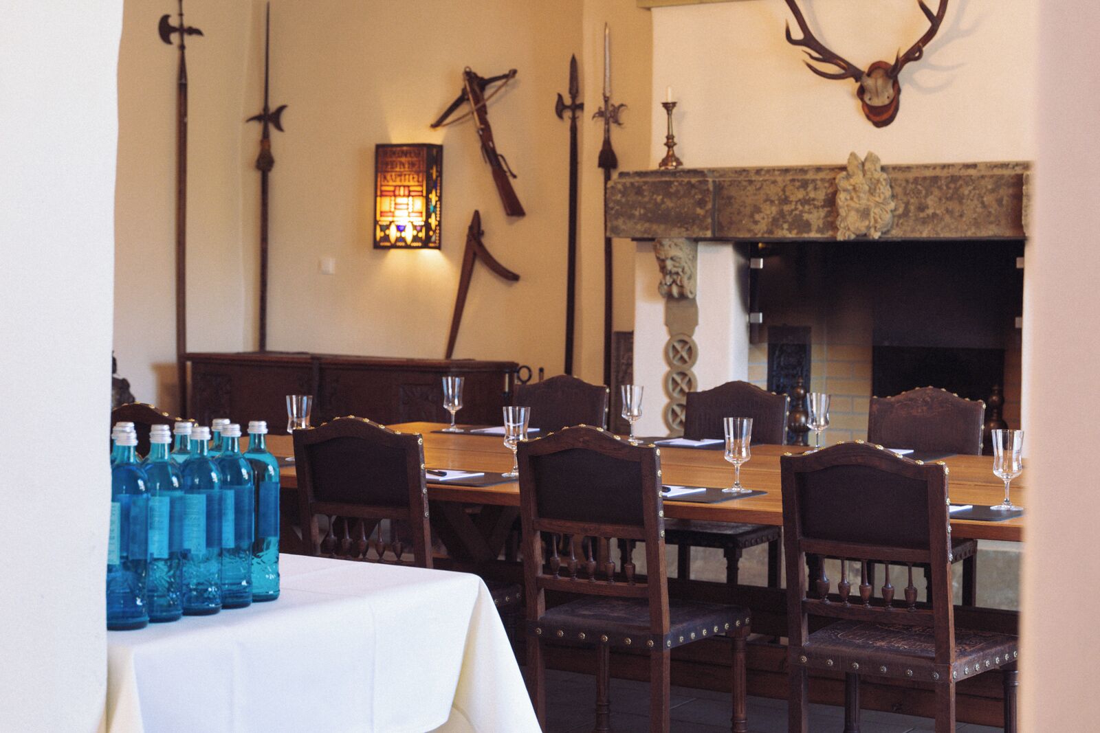 Comedor con una mesa larga dispuesta para cuatro personas, rodeada de sillas de madera.