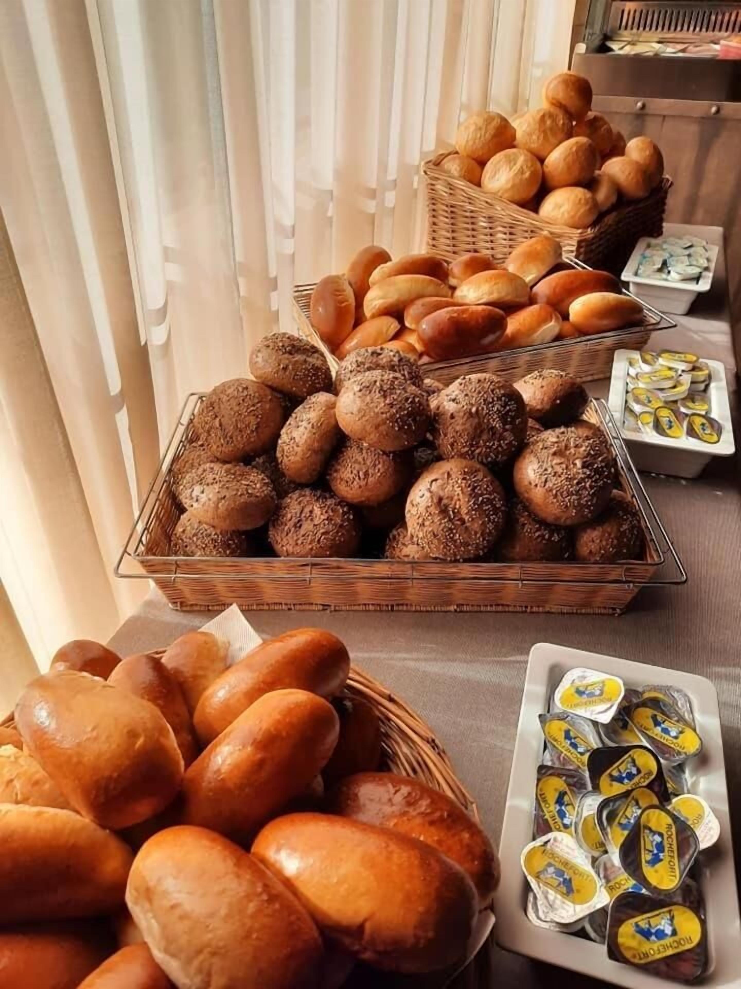 A buffet table with various breads and pastries.