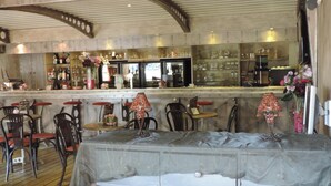 Una zona de bar con sillas de madera, una barra y una lámpara decorativa.