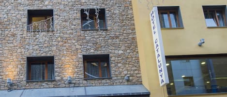 A hotel with a stone facade and a yellow building next to it.