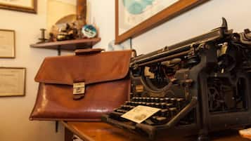 Eine antike Underwood Schreibmaschine auf einem Holztisch, neben ihr ein braunes Lederbriefcase.