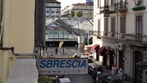 A street view with parked cars, a pedestrian crossing, and a building with balconies. - Anna's Family (Naples)