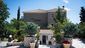 A hotel named 'Hotel Aliki' with a tiled roof, stone walls, and potted plants in the courtyard. - Aliki Hotel (Lefkada)