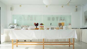 A buffet table with various food items and a glass display case in a bright, modern hotel setting.