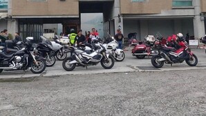 Un edificio con un letrero que dice '宋益' y una fila de motocicletas estacionadas en la entrada.