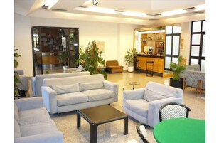 Un vestíbulo amplio con zona de estar, bar y mostrador de recepción.