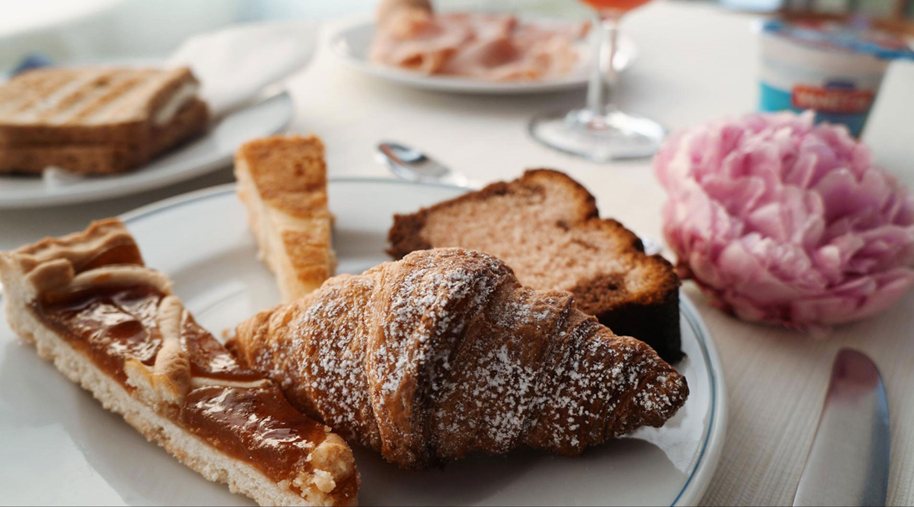 Eine Auswahl an Gebäck auf einem Teller, darunter ein Croissant und ein Tarte.
