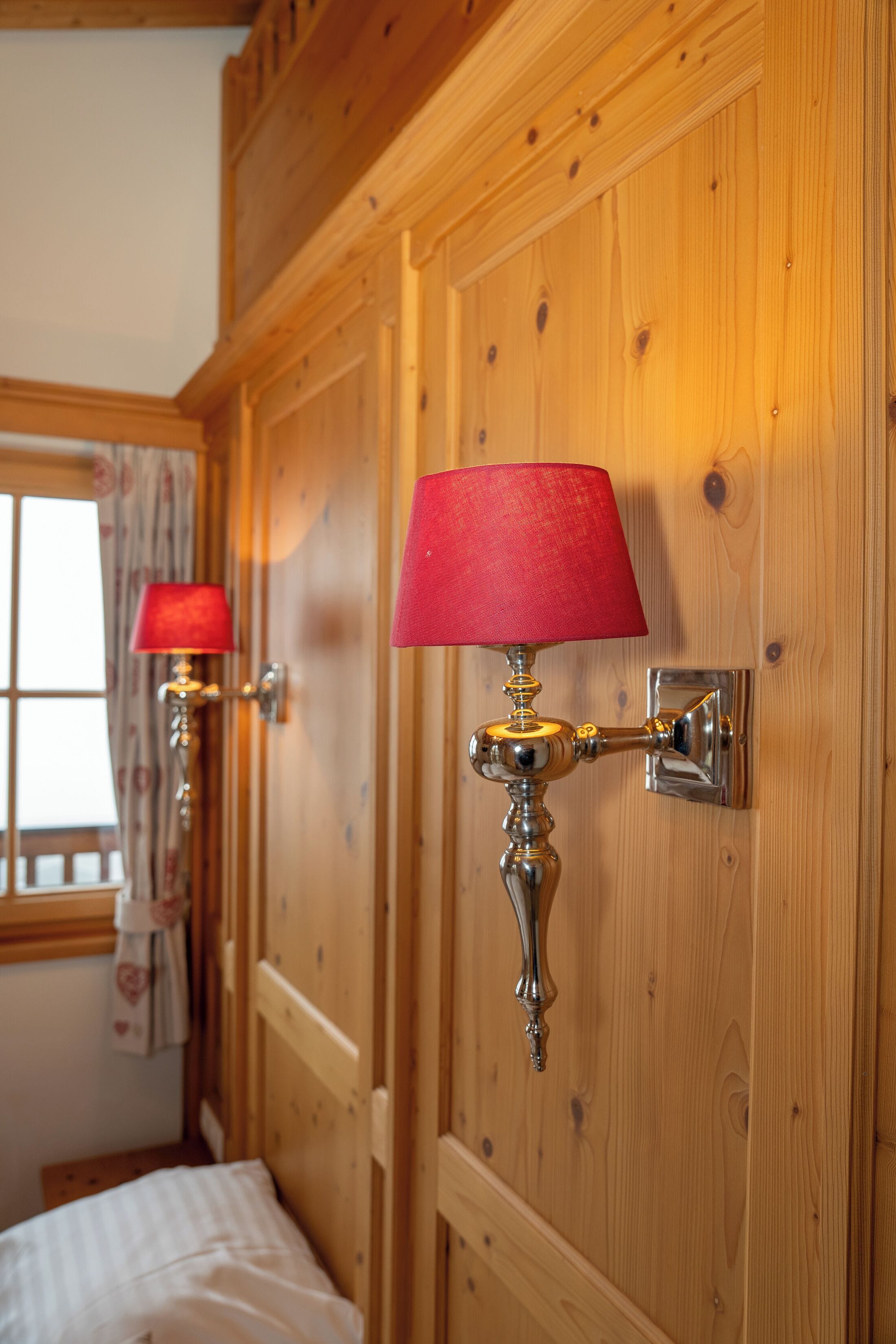 Eine Holzwand mit einer roten Lampe und einem Türgriff.